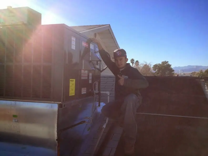 HVAC technician performing AC Tune-Up on a rooftop unit in Lehigh Acres